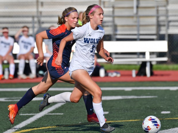 Oswego East's Anya Gulbrandsen (3) races with the ball ahead of Oswego's Gillian Young during their Class 3A Lockport Regional semifinal game on Wednesday, May 15, 2024, in Lockport.(Jon Cunningham/for The Beacon-News)