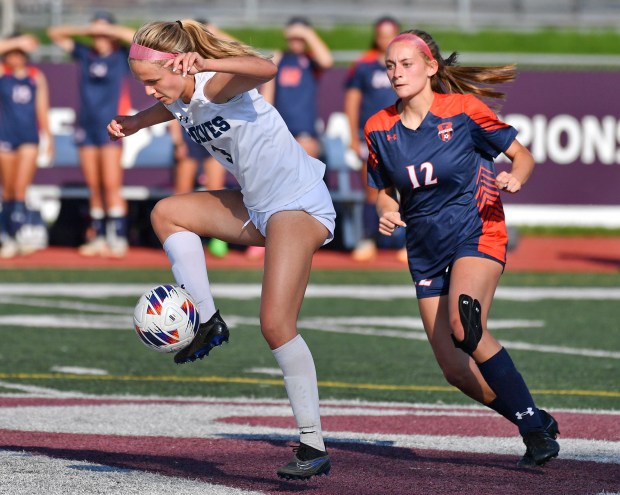 Oswego East's Anya Gulbrandsen controls the ball in front of Oswego's Ainsley Barnes (12) during their Class 3A Lockport Regional semifinal game on Wednesday, May 15, 2024, in Lockport.(Jon Cunningham/for The Beacon-News)