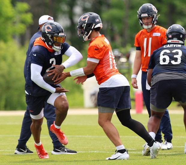 Chicago Bears quarterback Caleb Williams (18) hands off to wide receiver DJ Moore (2) during minicamp at Halas Hall on June 4, 2024, in Lake Forest. (Stacey Wescott/Chicago Tribune)