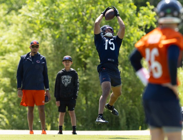 Chicago Bears wide receiver Rome Odunze (15) catches a pass while GM Ryan Poles and his son, Mason, watch him from the sidelines during Bears minicamp at Halas Hall on June 6, 2024, in Lake Forest (Stacey Wescott/Chicago Tribune)