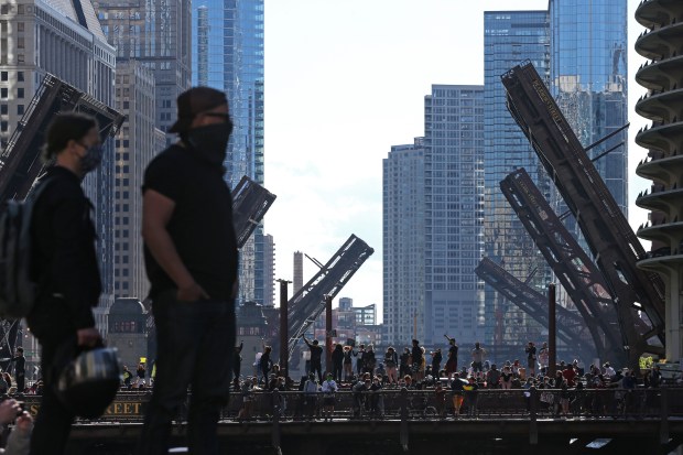 Protesters stand on the Wabash Avenue bridge as bridges to the west are lifted to prevent movement of people during a rally and march to remember the May 25 killing of George Floyd by a Minneapolis police officer, in the Loop on May 30, 2020, in Chicago. (John J. Kim/Chicago Tribune)