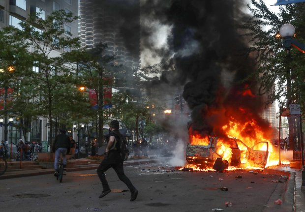 A Chicago police vehicle burns on North State Street in Chicago's Loop on May 30, 2020, after a rally to remember the May 25 killing of George Floyd by a Minneapolis police officer. (John J. Kim/Chicago Tribune)