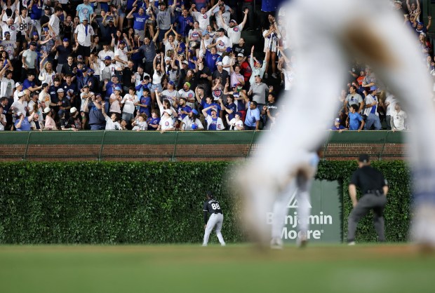 Fans reach for a walk-off home run ball hit by Cubs designated hitter Mike Tauchman, right, as he rounds the bases for a 7-6 win over the White Sox at Wrigley Field on June 5, 2024, in Chicago. (John J. Kim/Chicago Tribune)