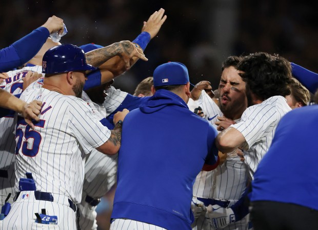 Cubs designated hitter Mike Tauchman, center right, is surrounded by teammates after hitting a walk-off home run for a 7-6 win over the White Sox at Wrigley Field on June 5, 2024, in Chicago. (John J. Kim/Chicago Tribune)