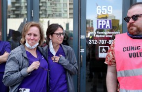 Employees from the Family Planning Associates clinic in downtown Chicago are overcome with emotion as abortion rights marchers pass by on May 14, 2022. (Chris Sweda/Chicago Tribune)