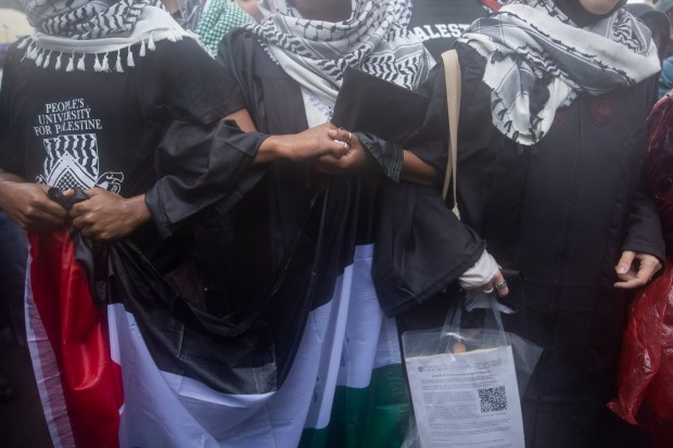 Pro-Palestine protesters link arms during a rally after University of Chicago students walked out of the university's convocation ceremony in support of Palestine on June 1, 2024, in Chicago. (Vincent Alban/Chicago Tribune)