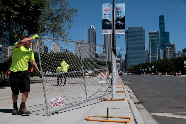 Workers put up fencing along Columbus Drive as street closures begin, June 10, 2024 in preparation for this year's NASCAR Chicago Street Race which takes place on July 6-7. (Antonio Perez/Chicago Tribune)