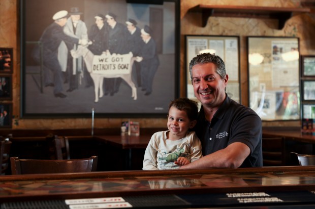 Co-owner Bill Sianis sits with his son, Ephraim, 3, in the newly opened Billy Goat Tavern in Wrigleyville on June 6, 2024. Sianis painted the goat painting behind him. (Eileen T. Meslar/Chicago Tribune)