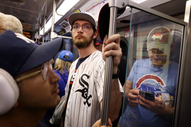 Chicago White Sox fan Steven Frankowski, center, and his father Russ Frankowski, not pictured, ride a CTA Red Line train from Addison to 35th Street in between attending both Cubs and White Sox home games on May 23, 2024. (Chris Sweda/Chicago Tribune)