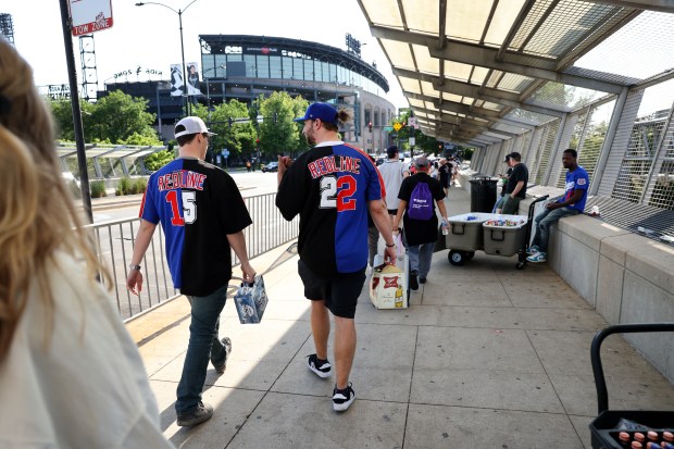 Eric Georgis, center, of Chicago's Humboldt Park neighborhood and Casey McAleer, of Lisle, wear their homemade Red Line half-Cubs half-White Sox jerseys as the duo arrives at the 35th Street CTA Red Line station on May 23, 2024. The two friends attended both Cubs and White Sox home games on Thursday, using the Red Line train to travel between Wrigley Field and Guaranteed Rate Field. (Chris Sweda/Chicago Tribune)