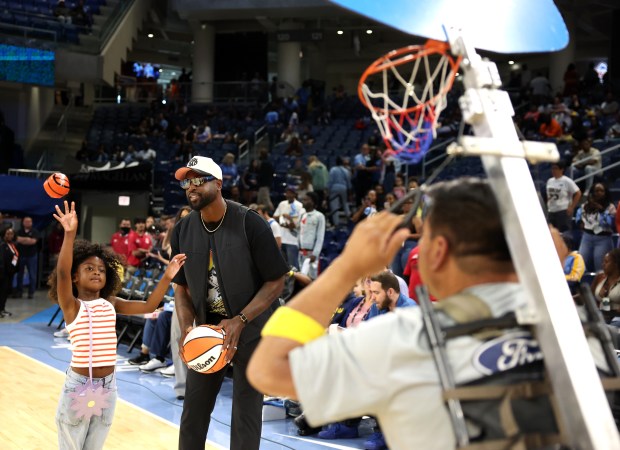 Dwyane Wade and his daughter hang out on the court before the Chicago Sky's home opener against the Connecticut Sun at Wintrust Arena in Chicago on May 25, 2024. (Chris Sweda/Chicago Tribune)