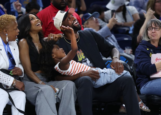 Dwyane Wade, Gabrielle Union, and their daughter pose have some fun while sitting courtside during the Sky's home opener against the Connecticut Sun at Wintrust Arena in Chicago on May 25, 2024. (Chris Sweda/Chicago Tribune)