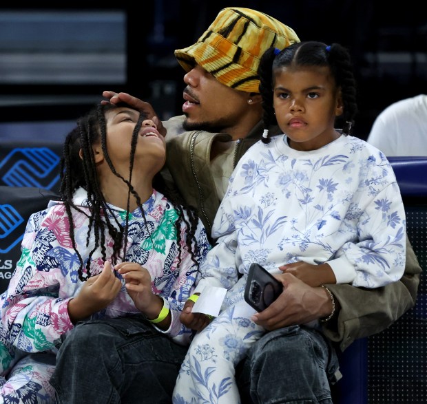 Chance the Rapper hangs out with his children while attending the Chicago Sky's home opener against the Connecticut Sun at Wintrust Arena in Chicago on May 25, 2024. (Chris Sweda/Chicago Tribune)