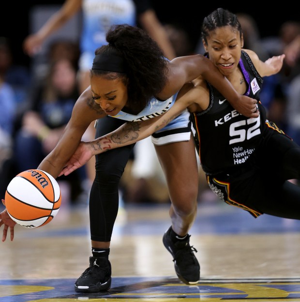 Chicago Sky guard Dana Evans (left) and Connecticut Sun guard Tyasha Harris (52) fight for a loose ball in the second half of the Sky's home opener at Wintrust Arena in Chicago on May 25, 2024. (Chris Sweda/Chicago Tribune)