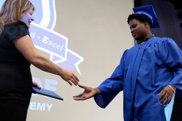 Southside Occupational Academy graduate Elijah Winston walks up on stage to receive his diploma during the graduation ceremony at Lindbloom Math and Science Academy on May 29, 2024. (Antonio Perez/Chicago Tribune)