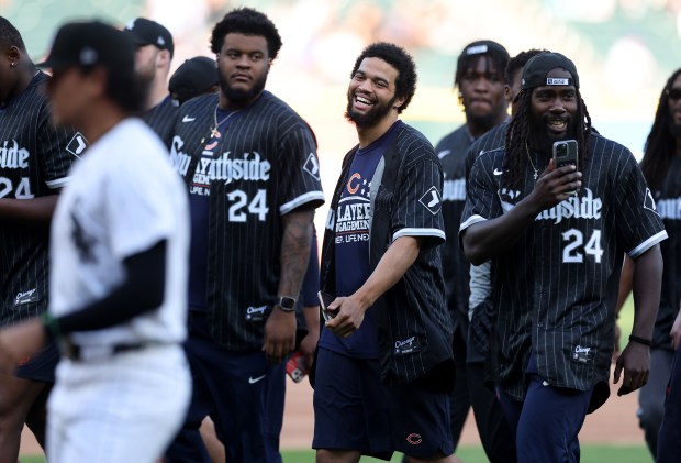 Chicago Bears quarterback Caleb Williams (center) has a laugh as Bears rookies walk off the field after wide receiver Rome Odunze threw out a ceremonial first pitch before a game between the Chicago Cubs and the Baltimore Orioles at Guaranteed Rate Field in Chicago on May 23, 2024. (Chris Sweda/Chicago Tribune)