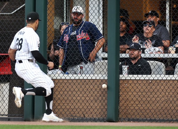 Atlanta Braves fans beyond the outfield wall watch as Chicago White Sox right fielder Tommy Pham (28) tracks down a ball that went for a run-scoring single for Baltimore Orioles catcher Adley Rutschman in the third inning of a game at Guaranteed Rate Field in Chicago on May 23, 2024. With the Cubs and Braves playing earlier in the day at Wrigley Field, many fans are attending both games in Chicago. (Chris Sweda/Chicago Tribune)