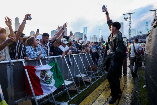 Alex Kinderman, right, dances and sprays other festival goers with water during the Sueños Festival at Grant Park on May 26, 2024. (Eileen T. Meslar/Chicago Tribune)