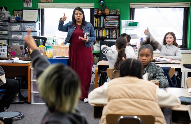 Rachael Mahmood and her fifth-grade class read a book about a book about Vietnamese refugees on March 11, 2024, in Aurora. (E. Jason Wambsgans/Chicago Tribune)