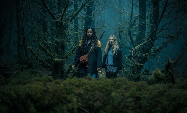 Two lost souls (Georgina Campbell and Dakota Fanning) explore a mysterious, unmapped forest in West Ireland in "The Watchers." (Warner Bros. Pictures)