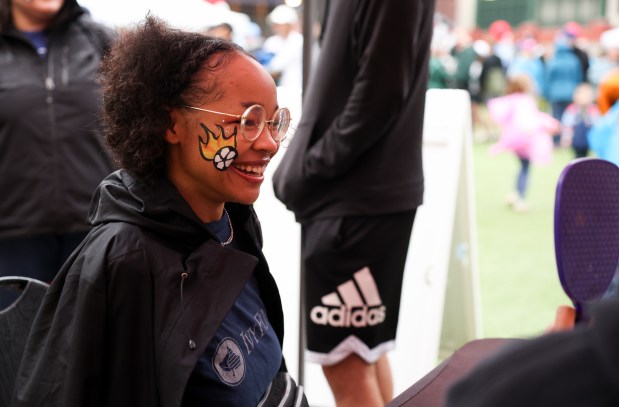 Jordyn Martin smiles as she looks at her face paint during the Chicago Red Stars Fan Fest at Gallagher Way before the Chicago Red Stars game against Bay FC at Wrigley Field on June 8, 2024. (Eileen T. Meslar/Chicago Tribune)