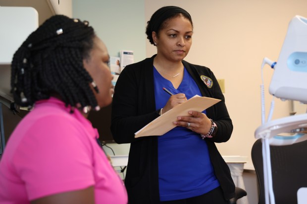 Licensed practical nurse Tearha Hill, right, takes the vitals of Yolanda Jones at Edward Hines Jr. VA Hospital. Hill serves as a chaperone in addition to her regular duties. (Stacey Wescott/Chicago Tribune)