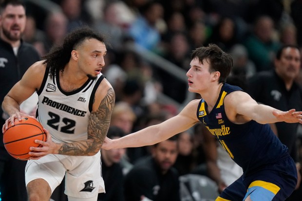 Providence guard Devin Carter (22) looks for an opening around Marquette guard Tyler Kolek during the second half of an NCAA college basketball game Tuesday, Dec. 19, 2023, in Providence, R.I. (AP Photo/Steven Senne)