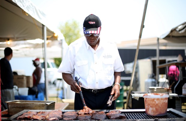 Charlie Robinson puts sauce on his ribs at Robinson's No. 1 Ribs during Ribfest in Naperville at Knoch Park in 2015.