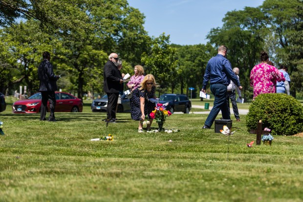 Laurie Crosby, of Franciscan Health, lays a few of the 27 roses June 12, 2024, placed in memoriam the 27 unborn babies who did not survive past 20 weeks in the womb, at Assumption Catholic Cemetery in Glenwood. (Vincent D. Johnson/for the Daily Southtown)